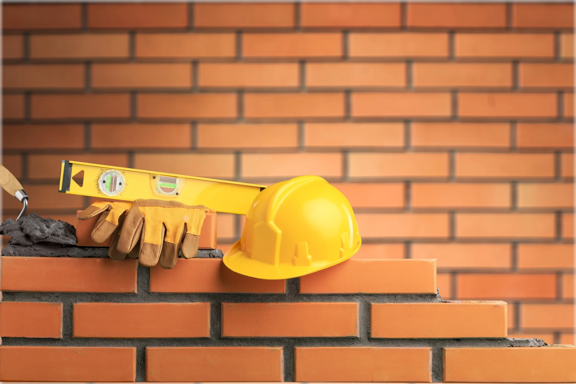 Chantier de construction avec mur de briques rouges en cours d'édification