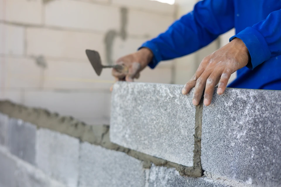 Trois professionnels du bâtiment analysent des plans architecturaux sur chantier